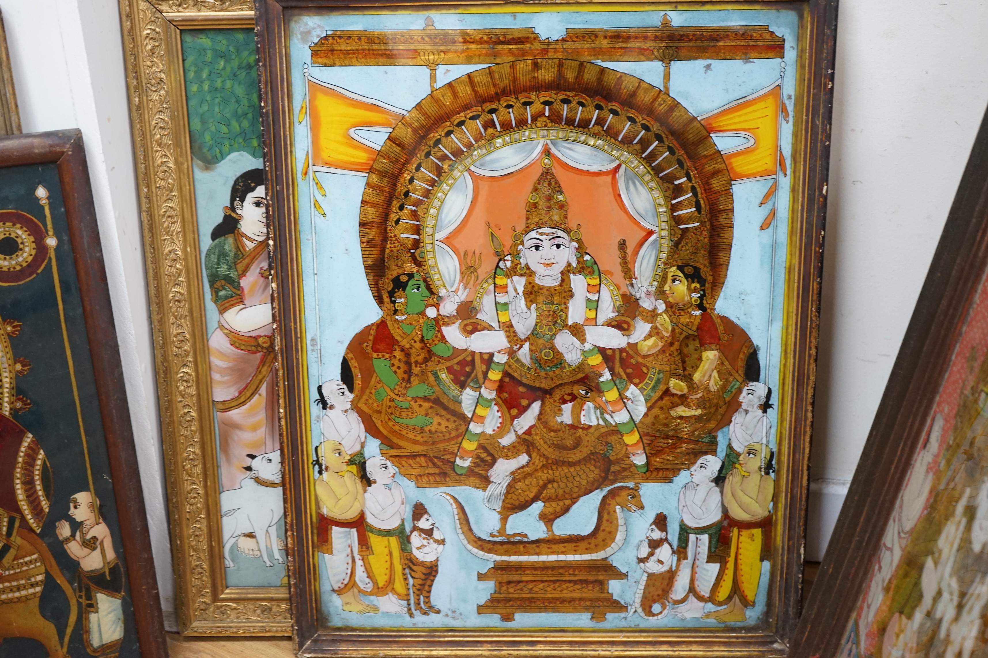 A collection of eight Indian reverse decorated glass pictures, 20th century, largest frame 70cm X 60cm